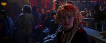 Movie still from “Never Been Kissed” (1999), directed by Raja Gosnell – A woman in a black top is in a room with a crowd; Close Up shot, Low angle