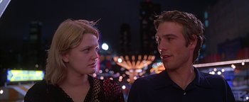 Movie still from “Never Been Kissed” (1999), directed by Raja Gosnell – A man and a woman standing next to each other in front of lights; Close Up shot, Over the shoulder angle