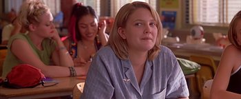 Movie still from “Never Been Kissed” (1999), directed by Raja Gosnell – A woman sitting in front of another woman in a room; Close Up shot, Over the shoulder angle