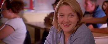 Movie still from “Never Been Kissed” (1999), directed by Raja Gosnell – A person sitting at a table; Close Up shot, Over the shoulder angle