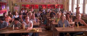 Movie still from “Never Been Kissed” (1999), directed by Raja Gosnell – A group of people sitting at tables in a room; Wide shot, High angle