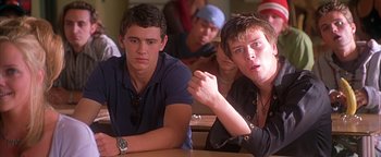 Movie still from “Never Been Kissed” (1999), directed by Raja Gosnell – Two young men sitting in front of a group of other young men; Close Up shot, Low angle