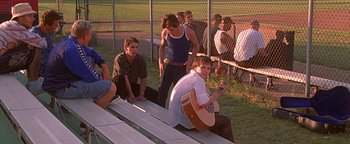 Movie still from “Never Been Kissed” (1999), directed by Raja Gosnell – A group of young men sitting on top of bleachers next to each other; Wide shot, Over the shoulder angle