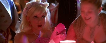 Movie still from “Never Been Kissed” (1999), directed by Raja Gosnell – A woman in a pink dress holding a pink object in front of her face; Close Up shot, Over the shoulder angle