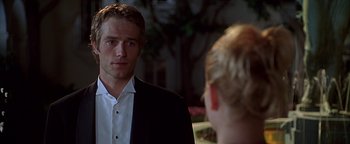 Movie still from “Never Been Kissed” (1999), directed by Raja Gosnell – A man in a suit looking at a woman in a black suit; Close Up shot, Over the shoulder angle