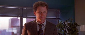 Movie still from “Never Been Kissed” (1999), directed by Raja Gosnell – A man wearing a suit and tie in front of a window; Close Up shot, Low angle