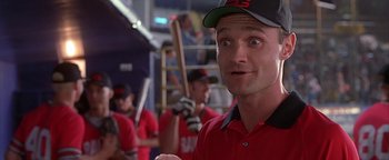Movie still from “Never Been Kissed” (1999), directed by Raja Gosnell – A man in a red shirt and a black and red hat is holding a baseball bat; Close Up shot, Low angle