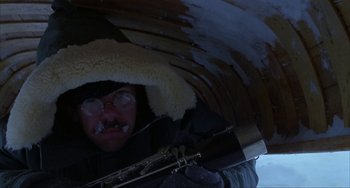 Movie still from “Never Cry Wolf” (1983), directed by Carroll Ballard – A man in a fur hat and glasses is holding a flute; Close Up shot, Low angle