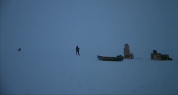 Movie still from “Never Cry Wolf” (1983), directed by Carroll Ballard – A man standing in the snow next to a boat; Extreme Wide shot, High angle