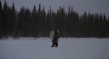 Movie still from “Never Cry Wolf” (1983), directed by Carroll Ballard – A man walking across a snow covered field; Extreme Wide shot, High angle