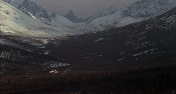 Movie still from “Never Cry Wolf” (1983), directed by Carroll Ballard – A view of a mountain range with snow on it's slopes; Extreme Wide shot, High angle