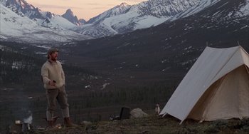 Movie still from “Never Cry Wolf” (1983), directed by Carroll Ballard – A man standing next to a tent in the mountains; Wide shot, Low angle