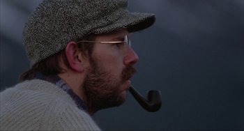 Movie still from “Never Cry Wolf” (1983), directed by Carroll Ballard – A man with a pipe in his mouth and wearing a hat; Close Up shot, Low angle