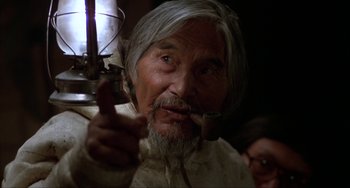 Movie still from “Never Cry Wolf” (1983), directed by Carroll Ballard – An old man with a long gray beard smoking a pipe; Close Up shot, Low angle