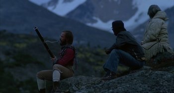 Movie still from “Never Cry Wolf” (1983), directed by Carroll Ballard – Two men sitting on a rock in front of a mountain range; Wide shot, Over the shoulder angle