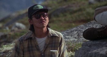 Movie still from “Never Cry Wolf” (1983), directed by Carroll Ballard – A man wearing a plaid shirt and a hat; Close Up shot, High angle