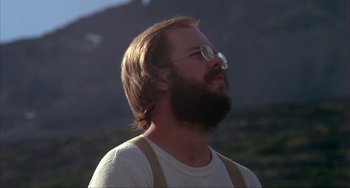 Movie still from “Never Cry Wolf” (1983), directed by Carroll Ballard – A man with a beard and glasses looking up at the sky; Close Up shot, Low angle