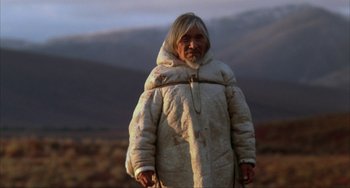 Movie still from “Never Cry Wolf” (1983), directed by Carroll Ballard – An old man in a white coat standing in a field; Medium shot, Low angle