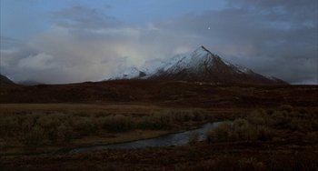 Movie still from “Never Cry Wolf” (1983), directed by Carroll Ballard – A view of a mountain range at night with a stream running through it; Extreme Wide shot, High angle