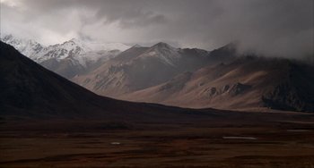 Movie still from “Never Cry Wolf” (1983), directed by Carroll Ballard – A view of a mountain range in the middle of a desert; Extreme Wide shot, High angle