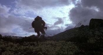 Movie still from “Never Cry Wolf” (1983), directed by Carroll Ballard – A man in a brown coat is walking in a field; Wide shot, Low angle