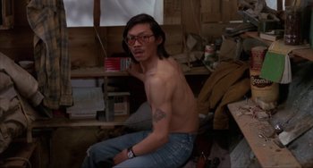 Movie still from “Never Cry Wolf” (1983), directed by Carroll Ballard – A man sitting on the ground in a room; Medium shot, High angle