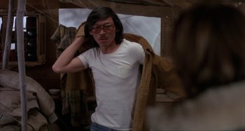 Movie still from “Never Cry Wolf” (1983), directed by Carroll Ballard – A man in a white shirt and a brown jacket; Medium shot, Low angle