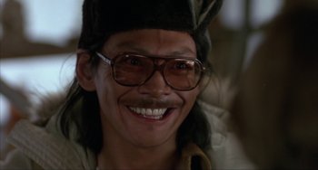 Movie still from “Never Cry Wolf” (1983), directed by Carroll Ballard – A man wearing a hat and glasses smiling for the camera; Close Up shot, Low angle
