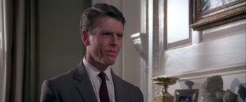 Movie still from “Never Say Never Again” (1983), directed by Irvin Kershner – A person wearing a suit and tie; Close Up shot, Over the shoulder angle