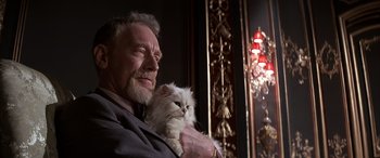 Movie still from “Never Say Never Again” (1983), directed by Irvin Kershner – An older man holding a white cat in his arms; Close Up shot, Low angle