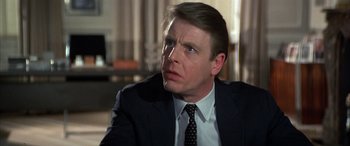 Movie still from “Never Say Never Again” (1983), directed by Irvin Kershner – A person wearing a suit and tie; Close Up shot, Over the shoulder angle