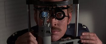 Movie still from “Never Say Never Again” (1983), directed by Irvin Kershner – A man is looking through a pair of eye glasses; Close Up shot, Low angle