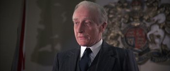 Movie still from “Never Say Never Again” (1983), directed by Irvin Kershner – An older man wearing a suit and tie; Close Up shot, Low angle