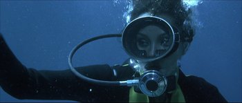 Movie still from “Never Say Never Again” (1983), directed by Irvin Kershner – A woman in a wet suit with a scuba mask on; Close Up shot, Overhead angle