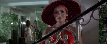 Movie still from “Never Say Never Again” (1983), directed by Irvin Kershner – A woman in a red dress and a red hat; Close Up shot, Low angle
