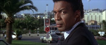 Movie still from “Never Say Never Again” (1983), directed by Irvin Kershner – A person wearing a suit and tie; Close Up shot, Over the shoulder angle