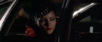 Movie still from “Never Say Never Again” (1983), directed by Irvin Kershner – A woman with a veil on her head looking out of a car window; Close Up shot, Over the shoulder angle