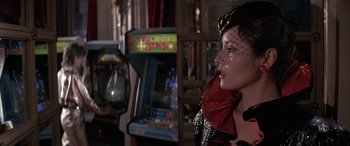 Movie still from “Never Say Never Again” (1983), directed by Irvin Kershner – A woman wearing a black and red jacket and a veil; Close Up shot, Over the shoulder angle
