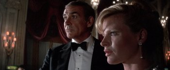 Movie still from “Never Say Never Again” (1983), directed by Irvin Kershner – A man and a woman in tuxedos looking into the distance; Close Up shot, Low angle