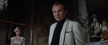 Movie still from “Never Say Never Again” (1983), directed by Irvin Kershner – A man in a white jacket and black tie; Close Up shot, Low angle