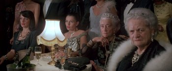 Movie still from “Never Say Never Again” (1983), directed by Irvin Kershner – A group of women sitting at a table with a glass of wine; Close Up shot, High angle