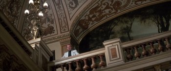 Movie still from “Never Say Never Again” (1983), directed by Irvin Kershner – A man standing on top of a wooden railing next to a railing; Wide shot, Low angle