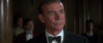Movie still from “Never Say Never Again” (1983), directed by Irvin Kershner – A man in a suit and bow tie looking to his left; Close Up shot, Low angle