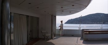 Movie still from “Never Say Never Again” (1983), directed by Irvin Kershner – A woman standing on a deck looking out at the ocean; Wide shot, Low angle