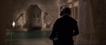 Movie still from “Never Say Never Again” (1983), directed by Irvin Kershner – A man standing in a room filled with statues; Wide shot, High angle
