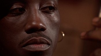 Movie still from “New Jack City” (1991), directed by Mario Van Peebles – View of a man's face with dark skin; Extreme Close Up shot, Low angle