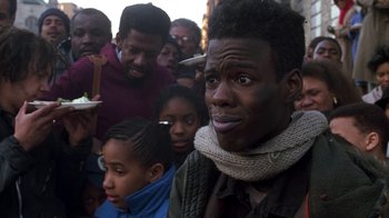 Movie still from “New Jack City” (1991), directed by Mario Van Peebles – A group of people standing in a crowd of men and women; Close Up shot, Over the shoulder angle
