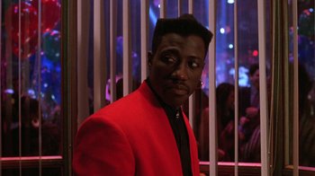 Movie still from “New Jack City” (1991), directed by Mario Van Peebles – A man in a red jacket standing in front of bars; Close Up shot, Over the shoulder angle