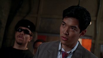 Movie still from “New Jack City” (1991), directed by Mario Van Peebles – A person wearing a suit and tie; Close Up shot, Over the shoulder angle