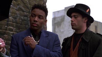 Movie still from “New Jack City” (1991), directed by Mario Van Peebles – A man in a blue jacket and a man in a black hat; Close Up shot, Low angle
